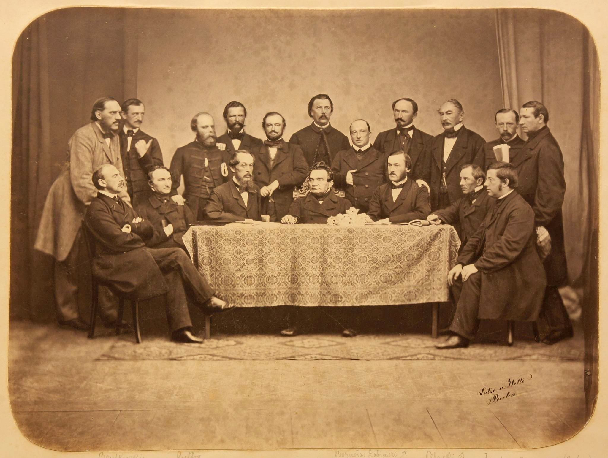 stara fotografia; zebranie Koła Polskiego na sejm pruski, 18 mężczyzn gromadzi się przy stole.