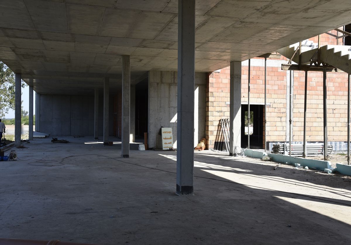 wnętrze budynku, widoczne kolumny, po lewej brak ściany, po prawej betonowa ściana