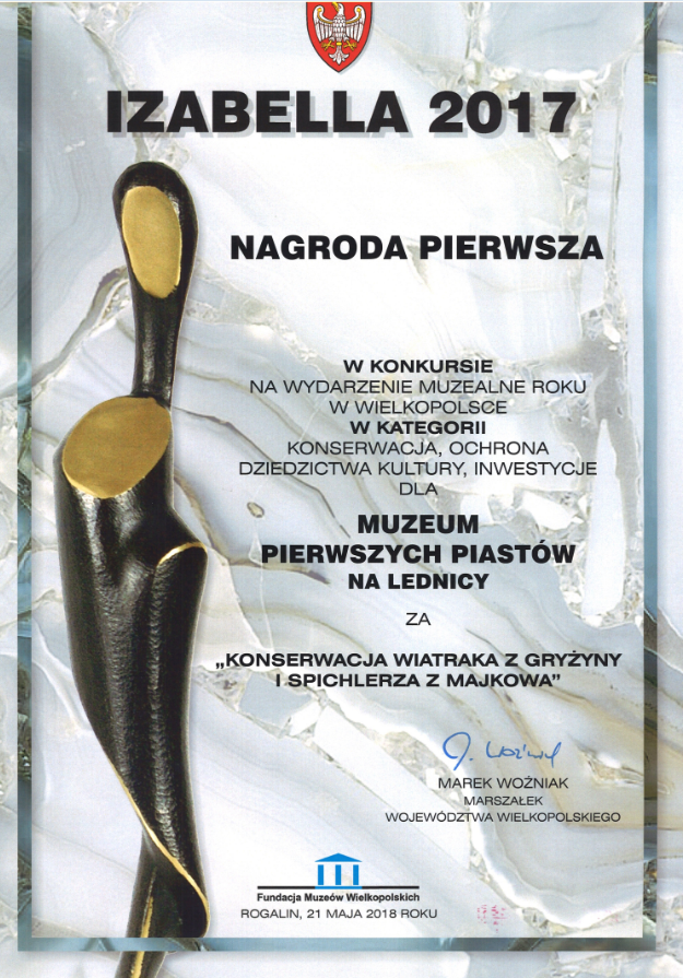 Dyplom nagrody Izabella z widoczną statuteką  po lewej stronie 