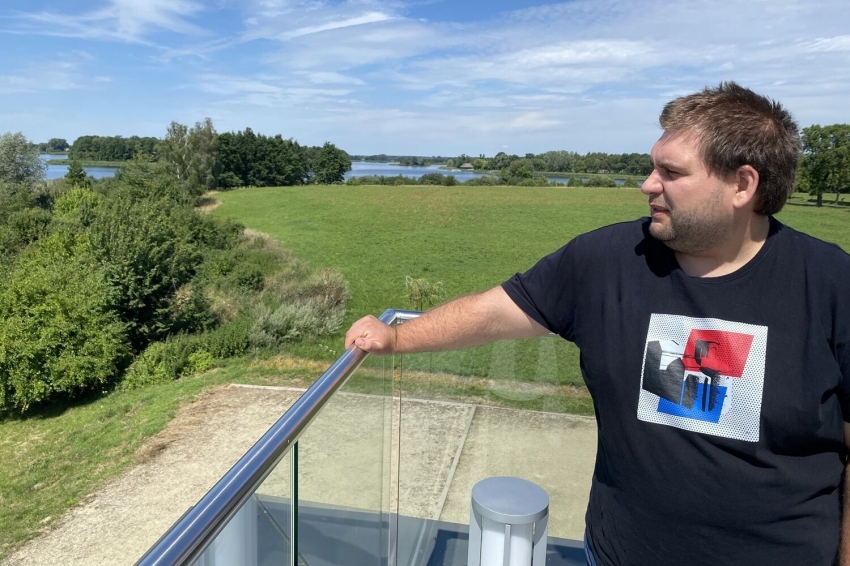 Na pierwszym planie Mateusz Wawrzyniak - archeolog. W tle Ostrów Lednicki