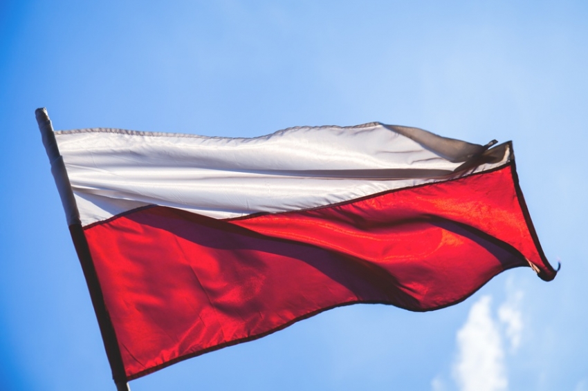 Flaga Polski, biało-czerwony kolor. W tle niebieskie niebo.