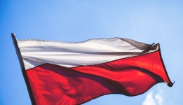 Flaga Polski, biało-czerwony kolor. W tle niebieskie niebo.