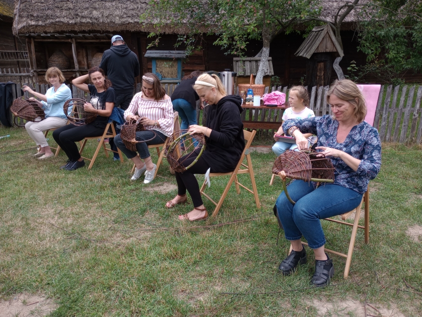 osoby siedzące na krześle, uczą się wyplatania koszy z wikliny 